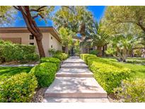 Beautiful walkway leading to a private residence with lush landscaping and mature trees at 9713 Highridge Dr, Las Vegas, NV 89134