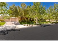 Charming single-story home features a well-manicured lawn and a two-car garage with mature landscaping at 9713 Highridge Dr, Las Vegas, NV 89134