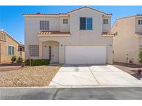 Two-story home with a two-car garage and low maintenance desert landscaping at 1153 Stormy Valley Rd, Las Vegas, NV 89123