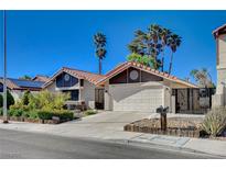 Charming single-story home featuring a two-car garage, landscaped front yard, and gated entry on a sunny day at 2704 Miraflores Ave, Las Vegas, NV 89102