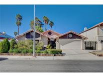 Charming single-story home with a two-car garage, desert landscaping, and terra cotta roof on a sunny day at 2704 Miraflores Ave, Las Vegas, NV 89102