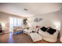 Bright living room featuring hardwood floors, neutral decor, and comfortable seating arrangement at 3151 Soaring Gulls Dr # 1181, Las Vegas, NV 89128