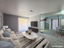 Bright living room features neutral tones, sliding glass doors and a dining area at 4400 Sandy River Dr # 4, Las Vegas, NV 89103