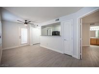 Bright living room featuring wood-style flooring, modern ceiling fan, and view to the bathroom and kitchen area at 5055 W Hacienda Ave # 1097, Las Vegas, NV 89118