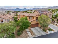 Inviting two-story home with a tile roof, attached garage, and desert landscaping against a scenic mountain backdrop at 617 Apricot Rose Pl, Las Vegas, NV 89138