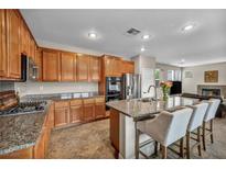 Spacious kitchen features an island with seating, stainless steel appliances, and granite countertops at 617 Apricot Rose Pl, Las Vegas, NV 89138