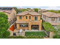 A charming two-story home featuring a balcony, covered patio, and a quaint fenced yard at 617 Apricot Rose Pl, Las Vegas, NV 89138
