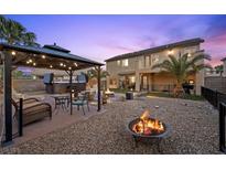 Outdoor living with a gazebo, fire pit, and hot tub for relaxation and entertaining in the landscaped backyard at 8208 Fritzen Ave, Las Vegas, NV 89131