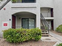 Exterior view of condo building with stairs to upper level and decorative green shrubbery at 950 Seven Hills Dr # 114, Henderson, NV 89052