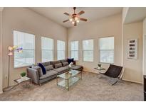 Bright living room boasts multiple windows, plush seating, ceiling fan and contemporary decor at 10001 Peace Way # 2231, Las Vegas, NV 89147
