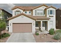 Two-story home featuring a neutral palette, symmetrical design, and a well-maintained front yard at 1180 Hollow Reed Ct, Henderson, NV 89011