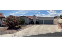 Charming single-story home featuring a two-car garage and desert landscaping at 1826 Dunes Ct, Laughlin, NV 89029