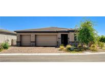 Beautiful single-story home featuring a three-car garage and landscaped front yard with a brick-paved driveway at 21 Reverie Heights Ave, Henderson, NV 89011
