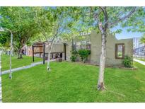 Quaint single-story home with a well-maintained lawn, trees, and unique architectural details at 4614 Grand Dr # 1, Las Vegas, NV 89169