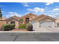 Beautiful exterior elevation showcases a three-car garage and desert landscaping at 5812 Spinnaker Reach Ave, Las Vegas, NV 89130