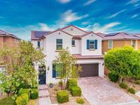 Charming two-story home with a brick driveway, landscaped yard and blue shutters at 9496 Wild Valley Ave, Las Vegas, NV 89148