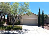 Charming single-story home featuring a well-manicured lawn, mature trees, and a two-car garage at 10195 Queensbury Ave, Las Vegas, NV 89135