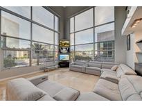 Bright, open living room with floor-to-ceiling windows and a large gray sectional sofa at 4515 Dean Martin Dr # 200, Las Vegas, NV 89103