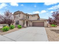 Inviting two-story stucco home with a well-manicured front yard and a spacious driveway leading to a two-car garage at 5960 Addy Ln, North Las Vegas, NV 89081