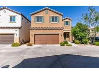 Two-story tan home featuring a two-car garage, neutral landscaping and a tile roof at 7609 Aubusson Ct, Las Vegas, NV 89149