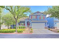 Charming two-story home with blue siding, red shutters, landscaped yard and a two car garage at 7728 Whispering River St, Las Vegas, NV 89131