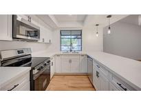 Beautiful kitchen featuring stainless steel appliances, white cabinets, quartz counters, and black hardware at 8412 Mulcahy Ave, Las Vegas, NV 89145
