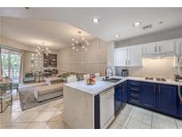 Open-concept kitchen with blue and white cabinets, complemented by a spacious living area at 91 E Agate Ave # 204, Las Vegas, NV 89123