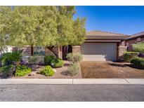 Charming single-story home featuring a two-car garage, stone accents, and mature landscaping at 936 Viscanio Pl, Las Vegas, NV 89138