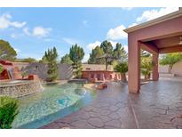 Resort-style pool features a rock waterfall, outdoor bar, and beautiful landscaping at 936 Viscanio Pl, Las Vegas, NV 89138