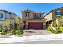 Charming two-story home featuring a red garage door, desert landscaping, and a brick-paved driveway at 10939 Cheshire Woods Ave, Las Vegas, NV 89166