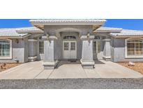 Inviting front entrance features a covered porch with decorative pillars and a double door entry for a grand arrival at 1410 Tiptop Trl, Pahrump, NV 89048