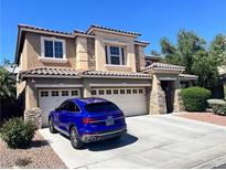 Charming two-story home with a three-car garage and a well-manicured front yard at 2112 Merganser Ct, North Las Vegas, NV 89084