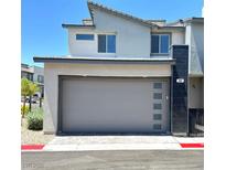 Modern two-car garage with gray door and brick-paved driveway on a sunny day at 483 Fairview Hills St, Las Vegas, NV 89138