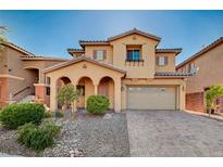Charming two-story home featuring a stucco exterior, arched entryway, and a well-maintained landscaped yard at 4937 Teal Petals St, North Las Vegas, NV 89081