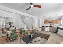 Bright living room featuring modern furnishings, hardwood floors, and an open floor plan leading to the kitchen and dining area at 9115 Weeping Hollow Ave, Las Vegas, NV 89178