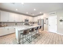 Modern kitchen features white cabinets, stainless steel appliances, and a spacious island with bar seating at 1267 Dorado Sea Ct, Henderson, NV 89052