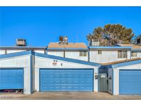 Exterior showing blue garages with white trim under a clear sky at 4078 Gold Coast Dr, Las Vegas, NV 89121
