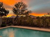 Backyard pool view showcasing desert landscape and beautiful sunset over the mountains at 437 Pinnacle Heights Ln, Las Vegas, NV 89144