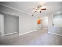 A spacious living room featuring modern gray wood flooring and a ceiling fan for comfortable living at 4400 S Jones Blvd # 2075, Las Vegas, NV 89103