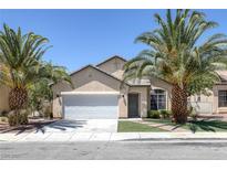 Inviting single-story home featuring desert landscaping with mature palm trees and an attached two-car garage at 5213 Giallo Vista Ct, North Las Vegas, NV 89031