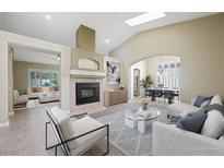 Bright living room with fireplace, neutral colors, vaulted ceiling, and skylight at 8541 Highland View Ave, Las Vegas, NV 89145