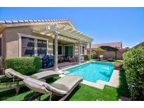 Beautiful backyard featuring a sparkling pool, lounge chairs, and a covered patio perfect for entertaining at 1081 Via Gandalfi, Henderson, NV 89011