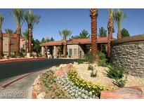 Inviting community entrance with stone accents, lush landscaping, and mature palm trees, offering a grand arrival experience at 2200 S Fort Apache Rd # 2062, Las Vegas, NV 89117