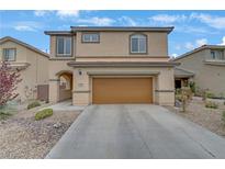 Two-story home featuring a tan exterior, two-car garage, and low maintenance desert landscaping at 2445 Rue Royale, Henderson, NV 89044