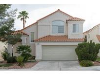 Charming home featuring a two-car garage, desert landscaping, and a classic tile roof at 2753 Devita Cir, Las Vegas, NV 89117