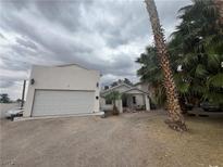 Quaint one-story home featuring a two-car garage and mature trees in a desert landscape at 4425 Sunflower Ave, Las Vegas, NV 89120