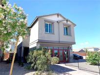Charming two-story home featuring a modern gray exterior, landscaped yard, and inviting red door, perfect for curb appeal at 6511 Dove Point Pl, Las Vegas, NV 89130