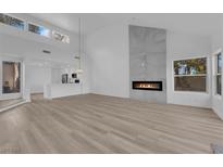 Bright living room features modern fireplace, wood floors, and open concept layout at 6940 Emerald Springs Ln, Las Vegas, NV 89113
