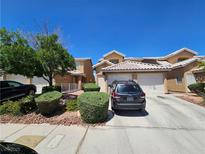 Inviting two-story townhome featuring a tile roof, well-manicured landscaping, and attached two-car garage at 8072 Cimarron Ridge Dr # 201, Las Vegas, NV 89128