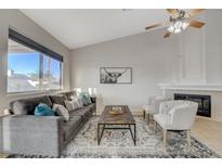 Bright living room featuring vaulted ceiling, fireplace, and large window for natural light at 832 Seco Verde Ave, Henderson, NV 89015